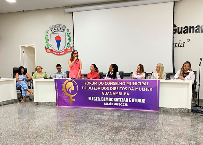 Fórum do CMDDM em Guanambi com autoridades e vereadoras debatendo combate à violência de gênero.